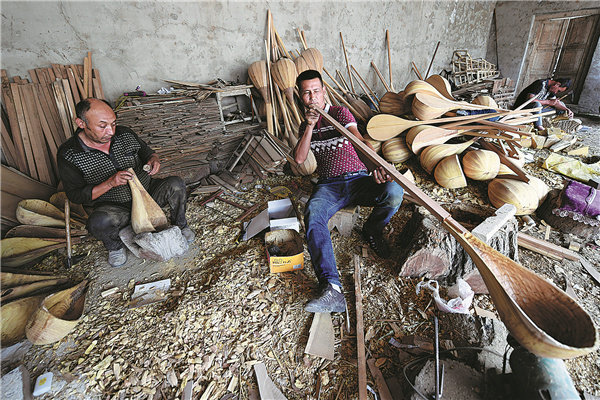 Vesničané ručně vyrábí hudební nástroje ve vesnici Jiayi (Ťia-i) v prefektuře Aksu v Ujgurské autonomní oblasti Xinjiang (Sin-ťiang). Asi 120 lidí z vesnice vyrobí každý rok 20 tisíc tradičních hudebních nástrojů. [Fotografie: Wei Xiaohao (Wej Siao-chao) / deník China Daily]